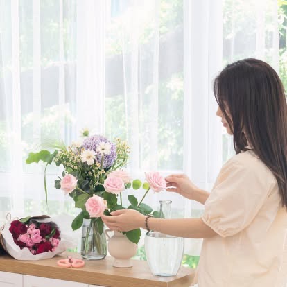 花束制作風景 - 明るい窓辺で花を整える様子